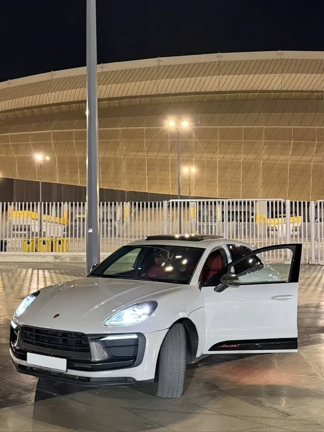 Porsche Macan T devant le stade, de nuit